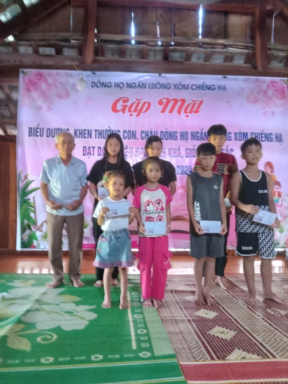 Ông Ngần Văn Cao, trưởng dòng họ Ngần Luông trao thưởng cho cho các em học sinh giỏi năm học 2023-2024